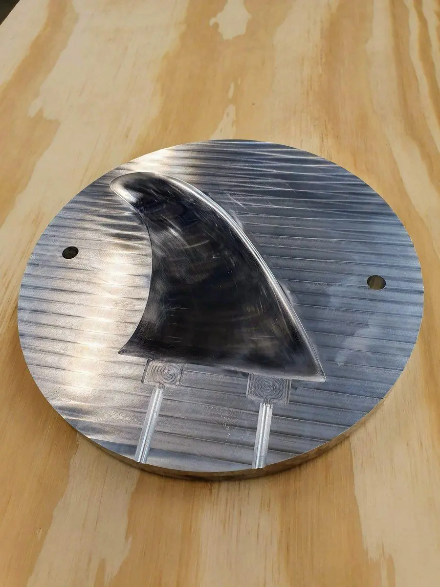 A machined aluminium plate with a fin profile cut into it