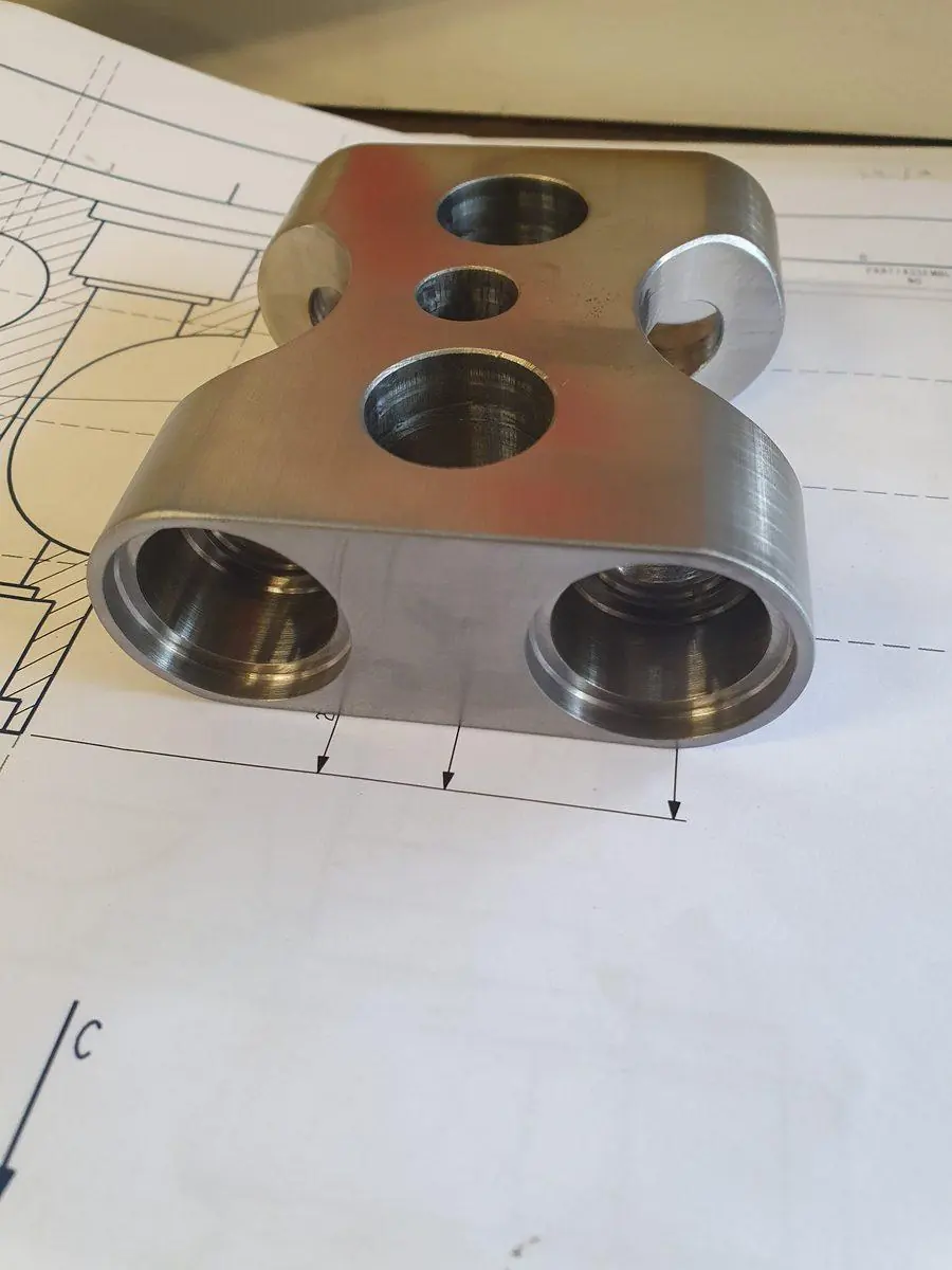 A machined part sitting on the drawing it was made from