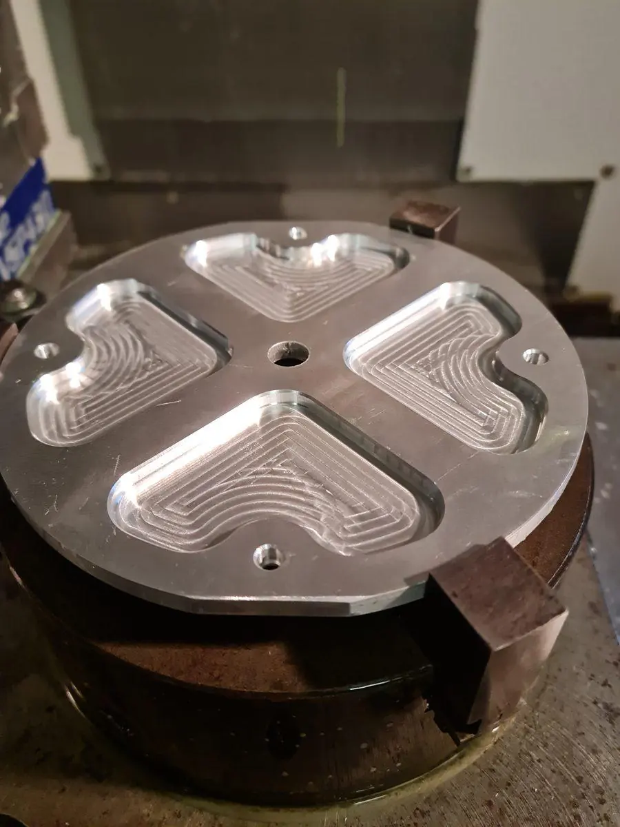 A plate held on the rotary table with pockets machined into the face